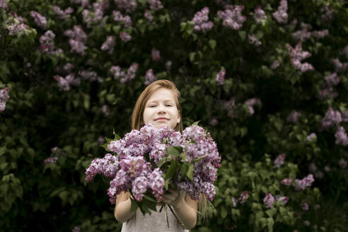 Nettes Mädchen hält frische Blumen in der Natur - ANF00063