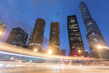 Light trails by illuminated buildings at night, Chicago, USA - WPEF05776