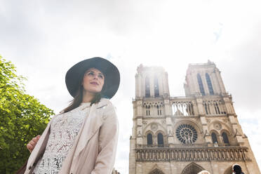 Junge Frau mit Hut vor der Kathedrale Notre Dame im Urlaub - WPEF05794