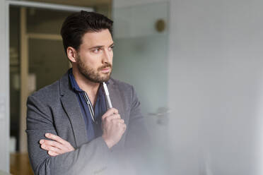 Bearded businessman thinking in office - DIGF17497