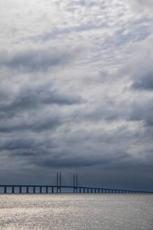 Bewölkter Himmel über der Meerenge von Sund mit der Silhouette der Öresundbrücke im Hintergrund - FOF12838