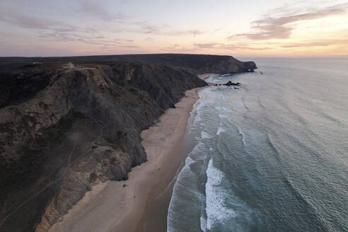 Portugal, Algarve, Vila do Bispo, Aerial view of Praia do Barranco beach at dawn - MKLF00039