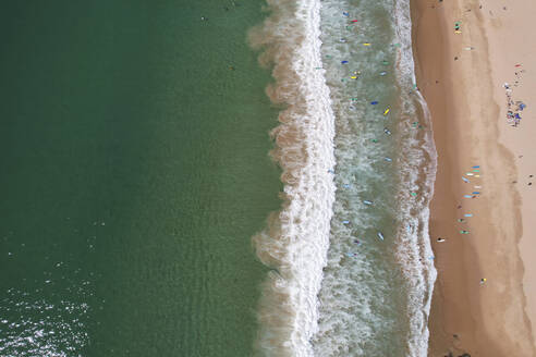 Portugal, Algarve, Vila do Bispo, Aerial view of surfers at Praia do Barranco beach - MKLF00040