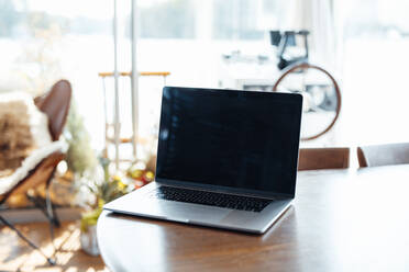 Laptop on wooden table at houseboat - GUSF06904