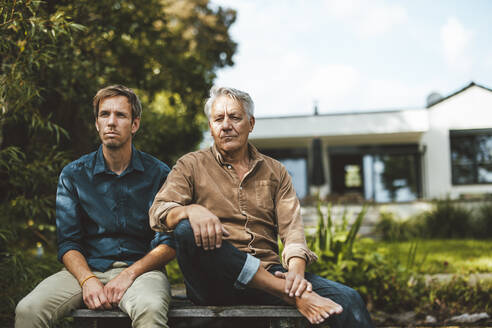 Vater und Sohn sitzen zusammen im Hinterhof - GUSF06925