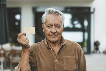 Älterer Mann mit weißem Haar hält Kreditkarte - GUSF07010