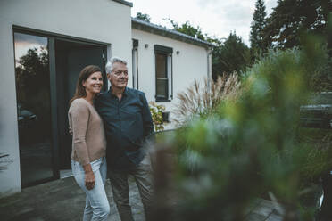 Lächelnde Frau mit älterem Mann vor einem Haus stehend - GUSF07019