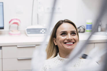 Happy young woman at dentist clinic - PNAF03050