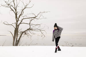 Mädchen in warmer Kleidung, das im Winter auf Schnee läuft - ANF00078