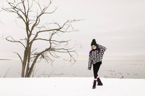 Girl wearing warm clothing walking on snow in winter - ANF00078