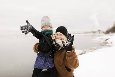 Cheerful mother and daughter enjoying in snow - ANF00084