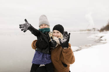 Fröhliche Mutter und Tochter, die sich im Schnee vergnügen - ANF00084
