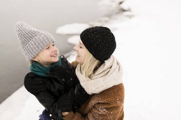 Glückliche Mutter und Tochter schauen sich im Winter an - ANF00085