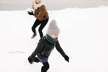 Glückliche Mutter und Tochter spielen mit Schnee im Winter - ANF00087