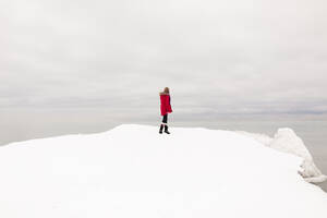 Mädchen steht im Schnee und betrachtet die Aussicht im Winter - ANF00091