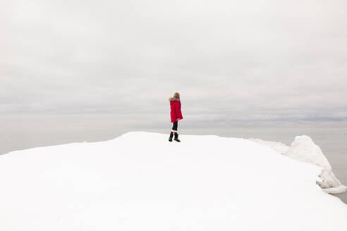 Girl standing on snow looking at view in winter - ANF00091