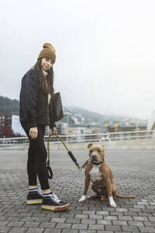 Frau mit Hund auf dem Fußweg stehend - MTBF01155