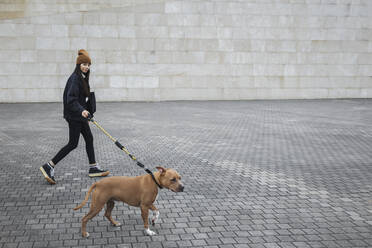 Frau mit Hund auf dem Fußweg an der Mauer - MTBF01157