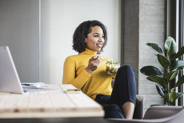 Nachdenkliche Geschäftsfrau mit Salat im Büro - UUF25471