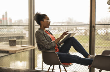 Businesswoman using tablet computer at work place - UUF25498