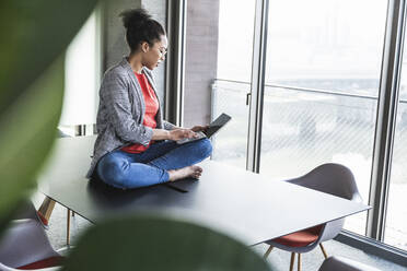 Young businesswoman working on laptop in office - UUF25517