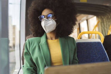 Geschäftsfrau mit Gesichtsschutzmaske in der Straßenbahn - JCCMF05288