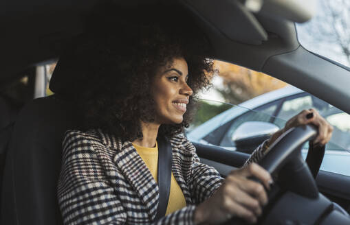 Lächelnde Frau am Steuer eines Autos auf einer Autoreise - JCCMF05336