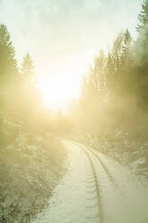 Deutschland, Sachsen, Oberwiesenthal, Schneebedeckte Gleise der Fichtelbergbahn bei Sonnenaufgang - PUF01990