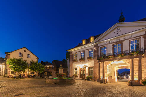 Frankreich, Elsass, Ribeauville, Leerer Stadtplatz und beleuchteter Eingang des Hotel de ville in der Abenddämmerung - WDF06806