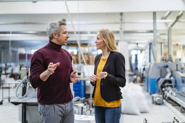 Businessman and businesswoman planning together in factory - DIGF17573