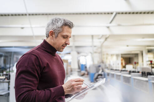 Geschäftsmann mit Tablet-PC bei der Arbeit in einer Fabrik - DIGF17585