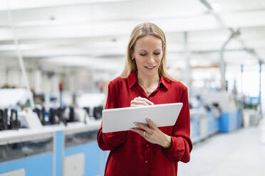 Geschäftsfrau mit Tablet-PC in einer Fabrik - DIGF17609