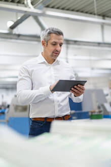 Geschäftsmann mit Tablet-PC bei der Arbeit in einer Fabrik - DIGF17682