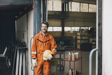 Portrait of smiling male blue-collar worker in uniform at warehouse - MASF28260