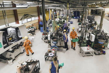 Weibliche und männliche Arbeiter in Uniform arbeiten in einem Fabriklager - MASF28266