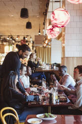 Männlicher Kellner, der Kunden im Restaurant Essen serviert - MASF28339