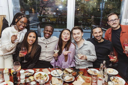 Cheerful multiracial female and male friends celebrating in bar afterwork - MASF28379