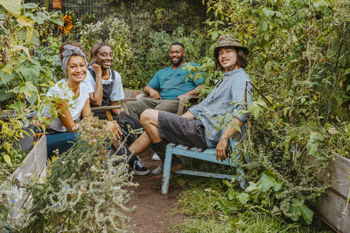 Portrait of male and female farmers sitting in organic farm - MASF28618