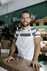 Porträt eines lächelnden männlichen Unternehmers in einer Bäckerei - MASF28789