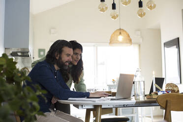 Mature couple using laptop on table at home - MASF28880