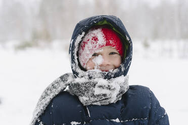 Glücklicher Junge mit Schnee auf dem Schal im Wald - SEAF00531