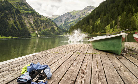 Boy jumping into Vilsalpsee lake from jetty - DIKF00625