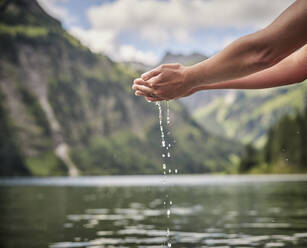 Wasser tropft aus den Händen einer Frau - DIKF00649