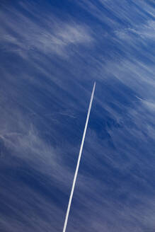 Flugzeug hinterlässt Kondensstreifen vor blauem Himmel - WWF06124