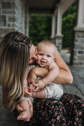 Zärtliche Mutter küsst süßen Sohn auf der Veranda - ELEF00030