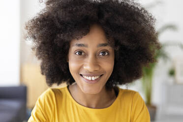 Happy young woman with black curly hair at home - XLGF02724