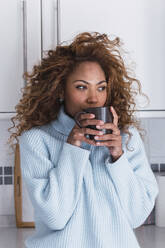 Young woman drinking coffee at home - PNAF03097
