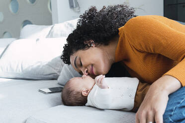 Mutter und kleiner Junge liegen auf dem Sofa zu Hause - PNAF03210