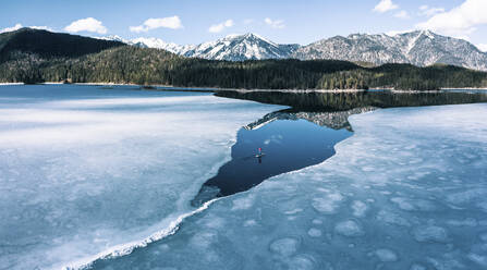 Deutschland, Bayern, Luftaufnahme eines einsamen Mannes beim Paddeln zwischen Eisschollen auf dem Eibsee - WFF00681