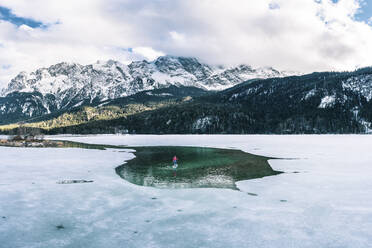 Deutschland, Bayern, Luftaufnahme eines einsamen Mannes beim Paddeln zwischen Eisschollen auf dem Eibsee - WFF00689